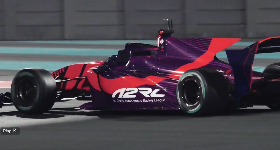 A2RL autonomous formula racing car speeding on track in Abu Dhabi at night, showcasing futuristic design and high-performance technology