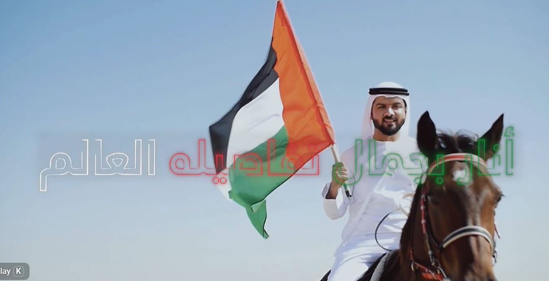 Emirati man riding a horse holding the UAE flag in the desert celebrating UAE National Day